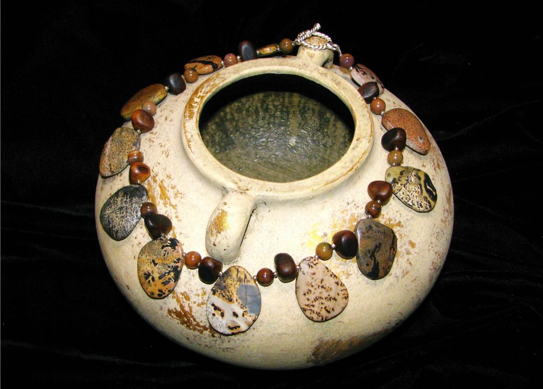 A bowl with rocks and beads around it.