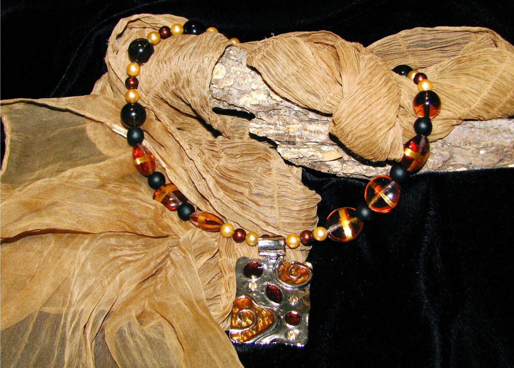 A necklace with beads and a metal piece.