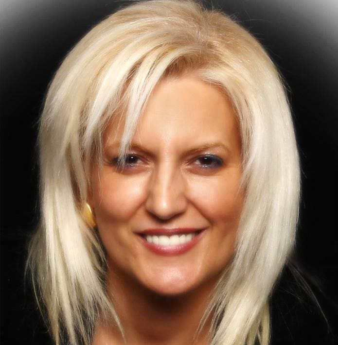 A woman with blonde hair and blue eyes.
