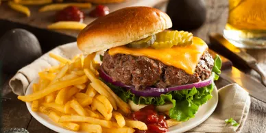 cr=w_388,h_194 (2) Juicy cheeseburger with fries and pickles.