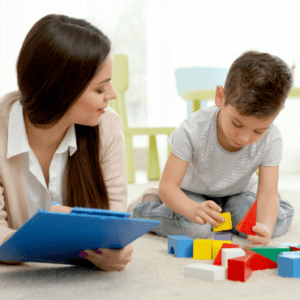 Therapist plays with child using blocks.