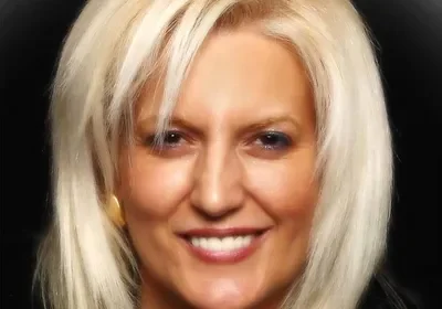 Here's an alt tag for the image: Headshot of blonde woman smiling.